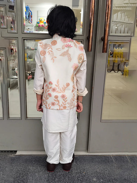 Person wearing a floral embroidered outfit standing in front of a kidswear store