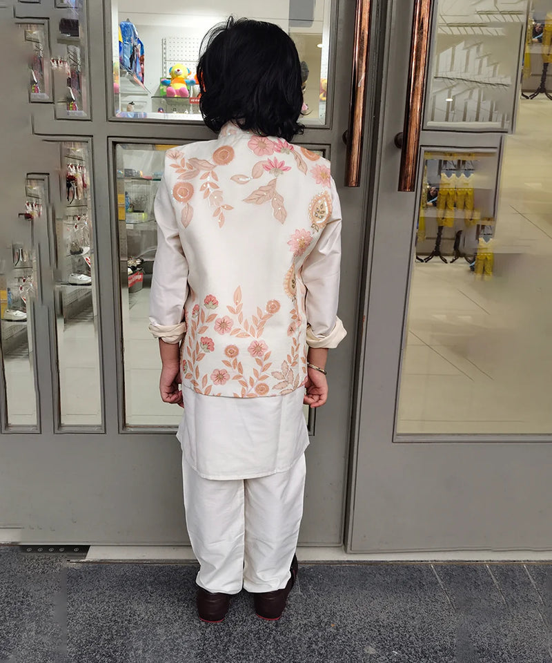 Person wearing a floral embroidered outfit standing in front of a kidswear store