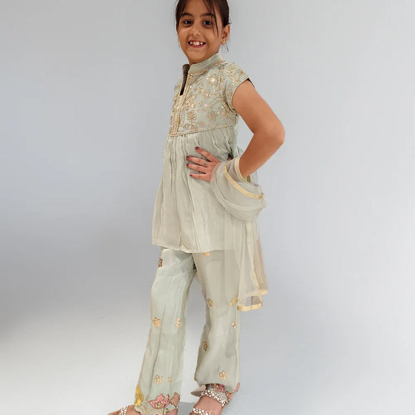 Young girl wearing a traditional outfit with a plain background