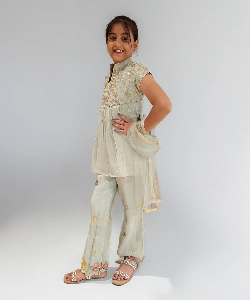 Young girl wearing a traditional outfit with a plain background