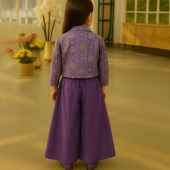 Child wearing a purple outfit with a patterned top and long skirt in an indoor setting.