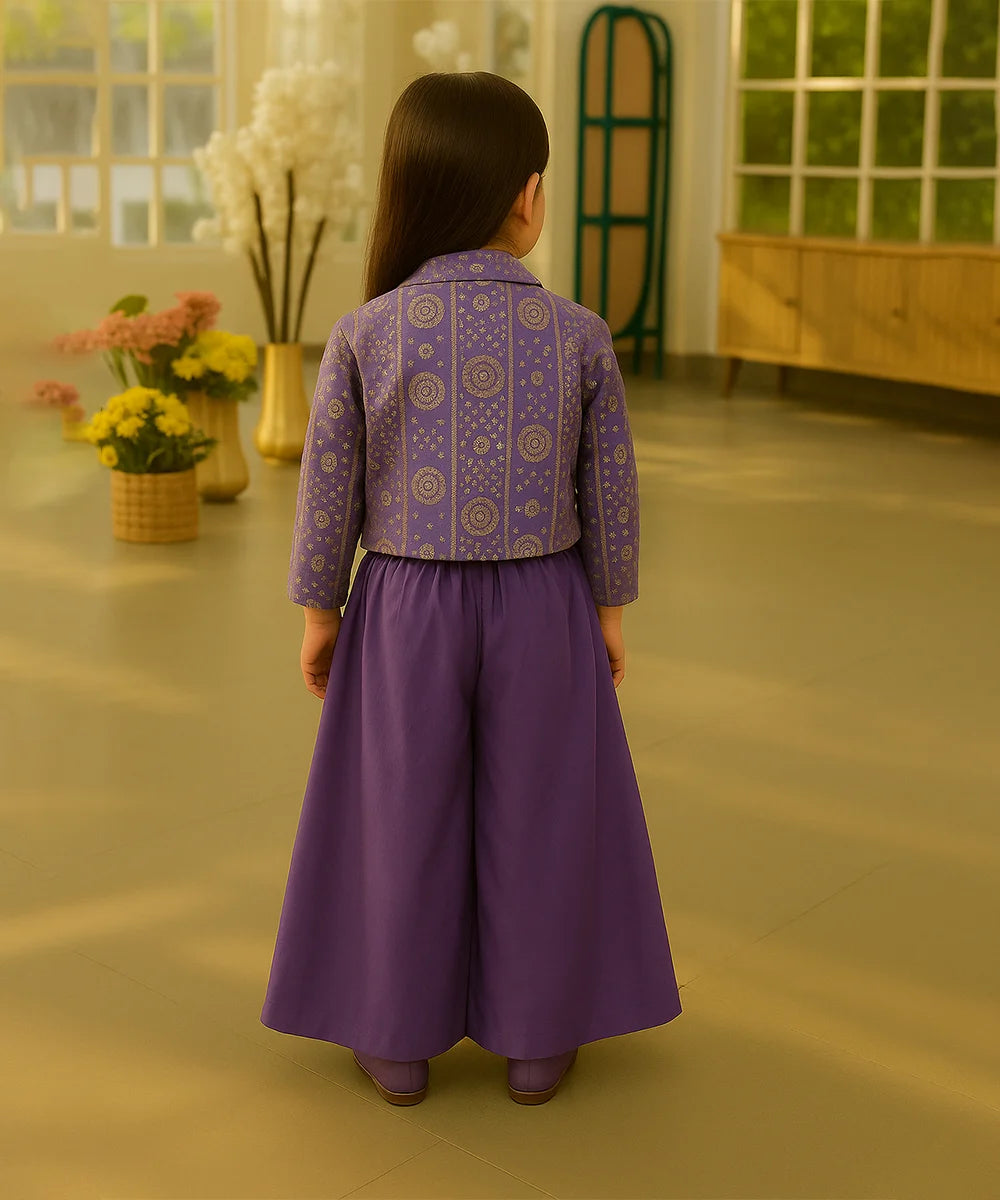 Child wearing a purple outfit with a patterned top and long skirt in an indoor setting.