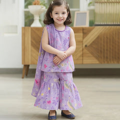 baby girl in a purple floral dress standing indoors