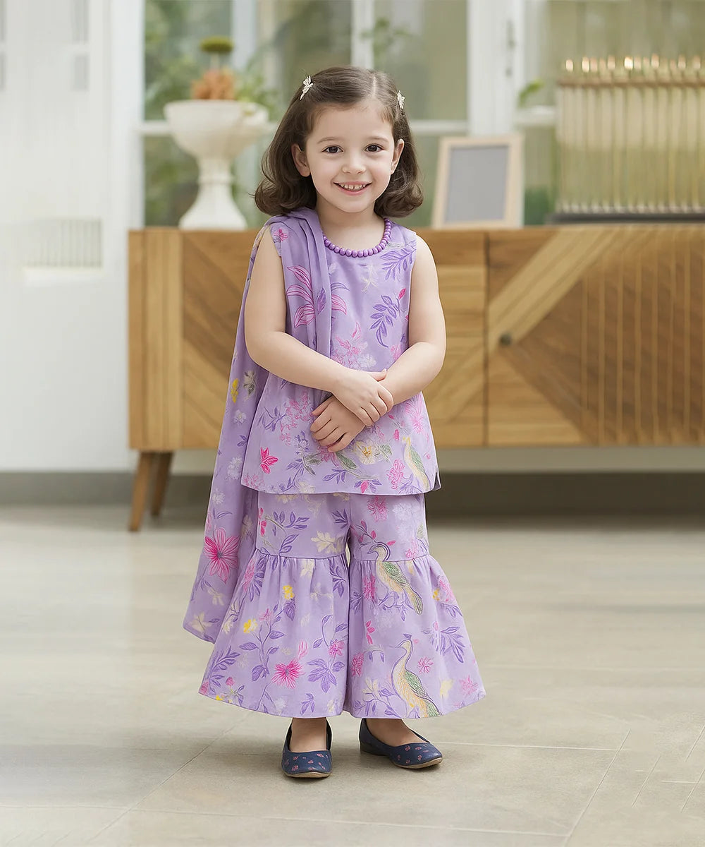 baby girl in a purple floral dress standing indoors