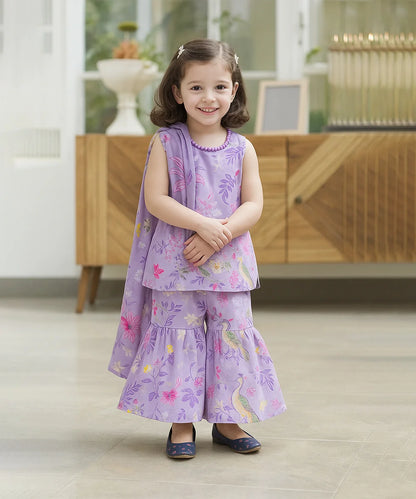 baby girl in a purple floral dress standing indoors