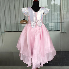 Pink dress with silver bow on a mannequin against a neutral background