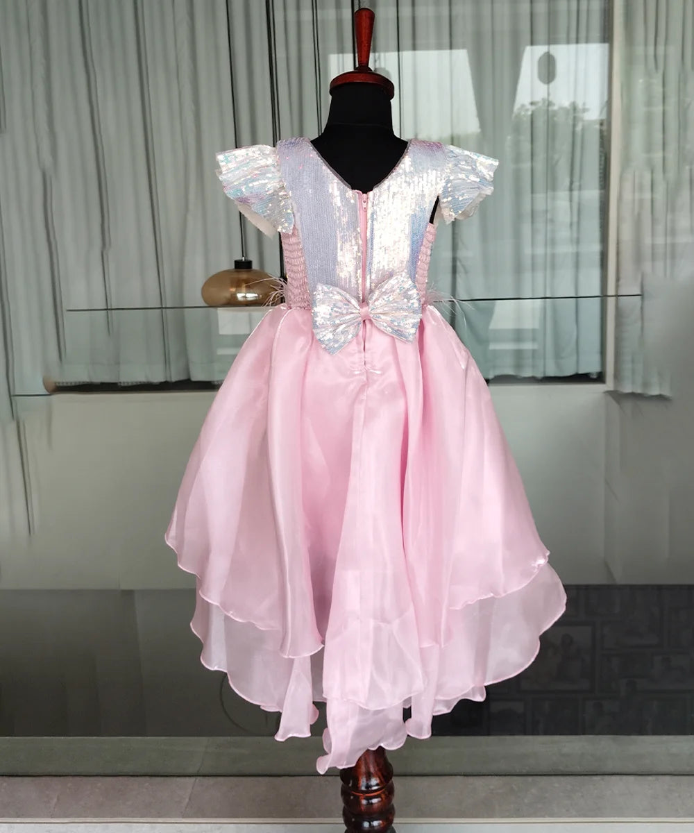 Pink dress with silver bow on a mannequin against a neutral background