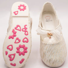 Close-up of newborn ivory glitter slip-on shoes with quilted insole and embellished bow, Jaipur