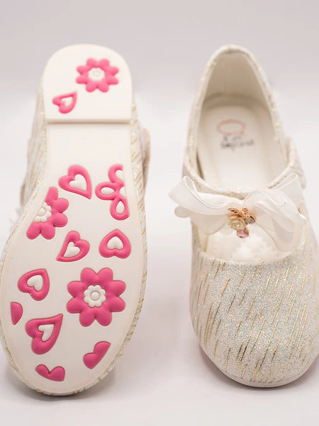 Close-up of newborn ivory glitter slip-on shoes with quilted insole and embellished bow, Jaipur