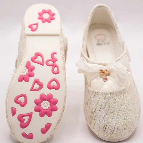 Close-up of newborn ivory glitter slip-on shoes with quilted insole and embellished bow, Jaipur