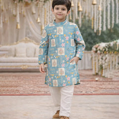 Child wearing a blue patterned kurta with white pants in a decorated indoor setting