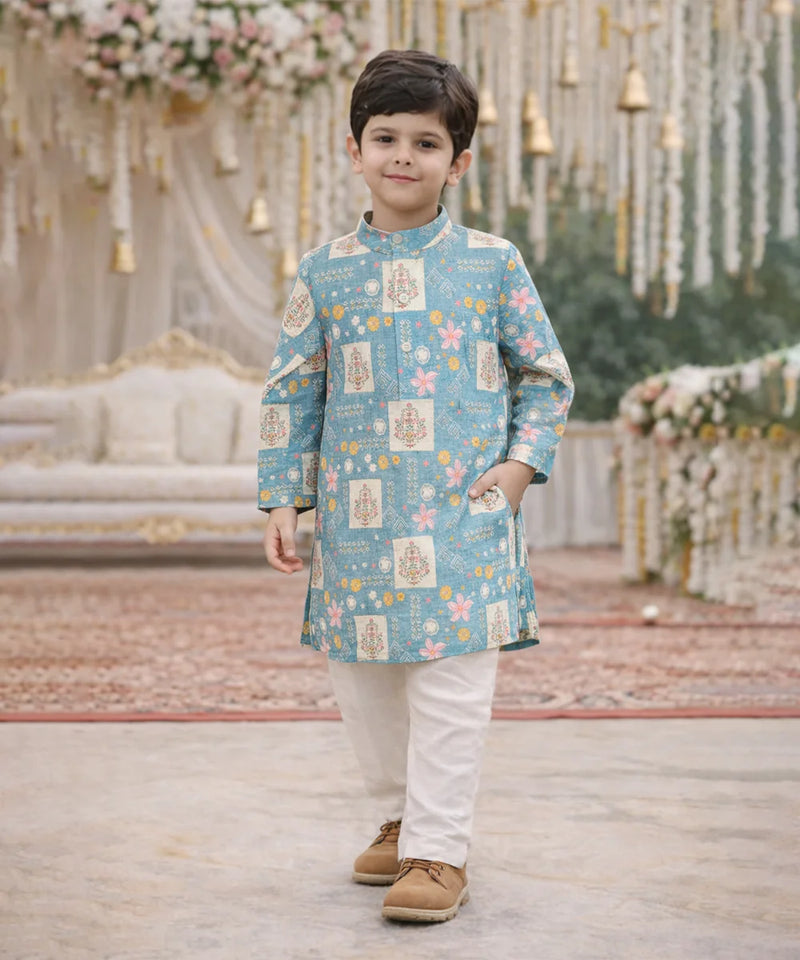 Child wearing a blue patterned kurta with white pants in a decorated indoor setting