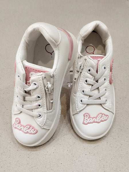 White sneakers with pink accents and 'Barbie' branding on a beige background