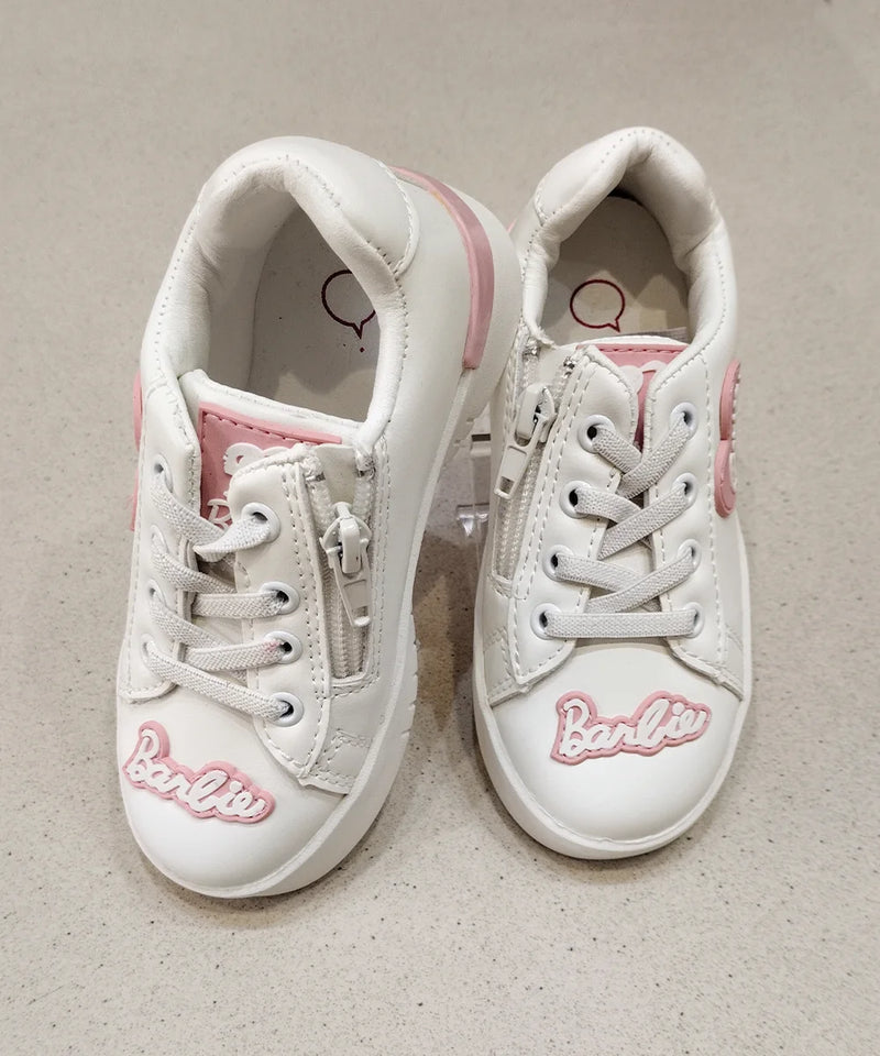 White sneakers with pink accents and 'Barbie' branding on a beige background