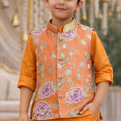 Child wearing an orange embroidered vest over a matching shirt with a blurred decorative background