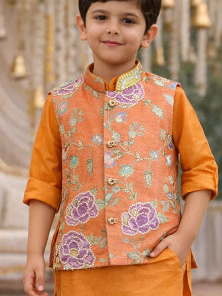 Child wearing an orange embroidered vest over a matching shirt with a blurred decorative background