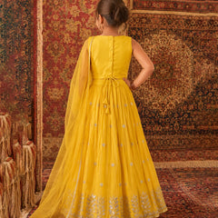 Woman in a yellow dress standing on a patterned rug