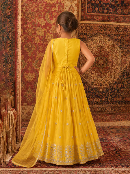Woman in a yellow dress standing on a patterned rug