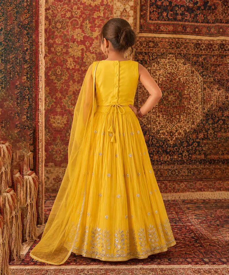 Woman in a yellow dress standing on a patterned rug