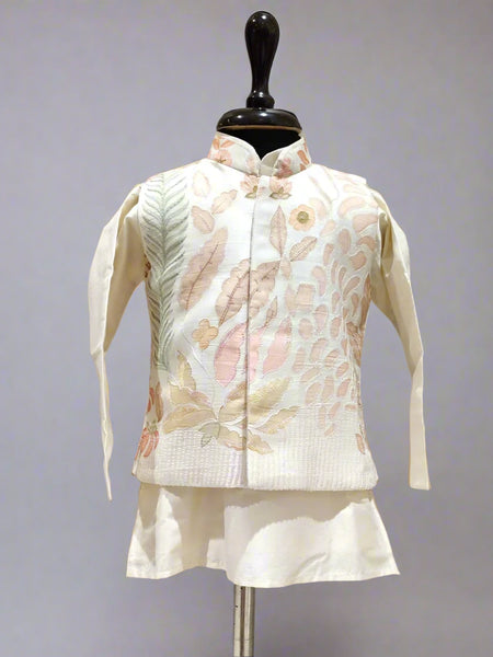 A cream color kurta jacket set displayed on a mannequin, consisting of a jacket with floral embroidery and a pair of shorts.