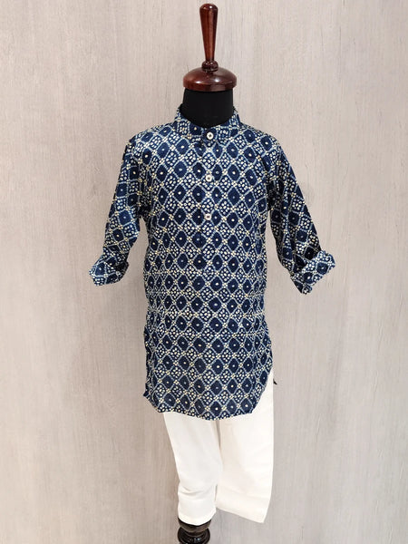 Blue patterned kurta with white pants on a mannequin against a beige background