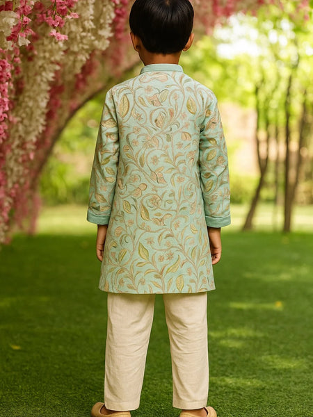 Child wearing a traditional outfit with paisley patterns in a garden setting