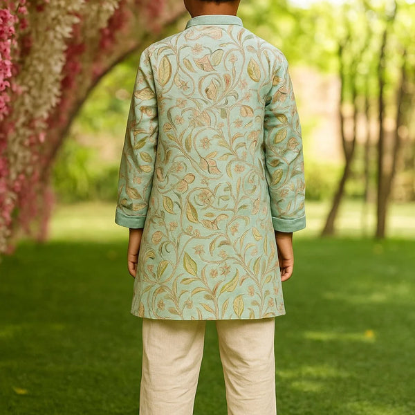 Child wearing a traditional outfit with paisley patterns in a garden setting