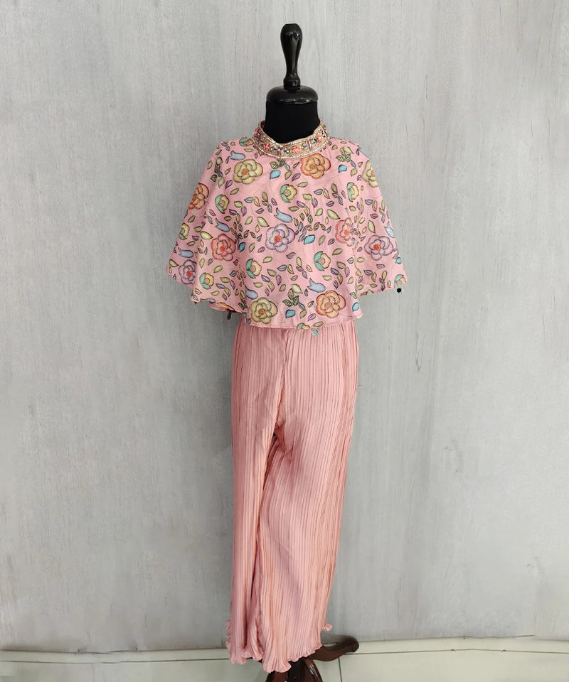 Mannequin wearing a pink floral top and pleated pants against a gray background