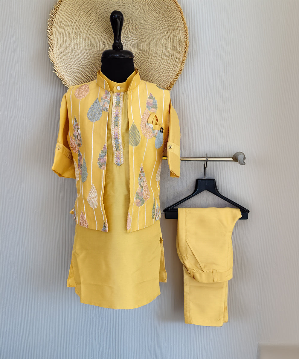 Yellow outfit with matching pants on a mannequin and hanger against a light gray wall.