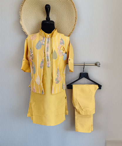 Yellow outfit with matching pants on a mannequin and hanger against a light gray wall.