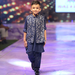 Child model walking on a fashion show runway wearing a navy blue color kurta pajama traditional outfit.