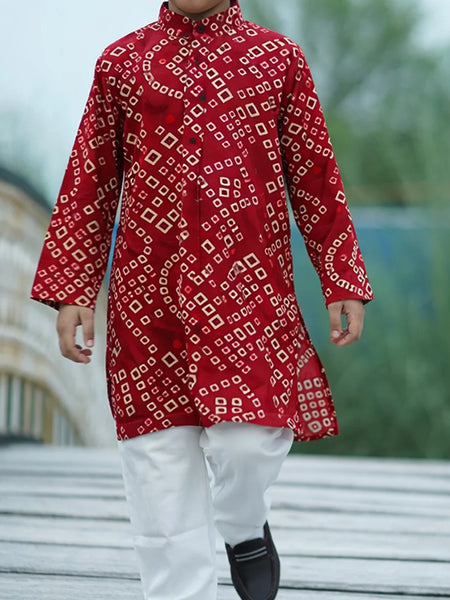 Red patterned kurta with white pants worn by a person outdoors.