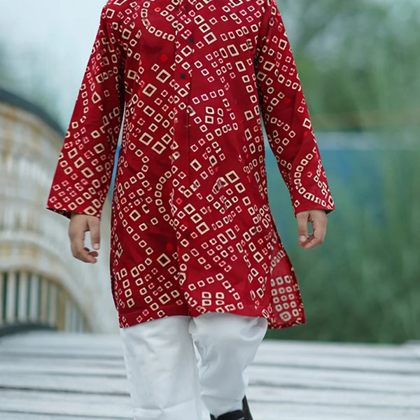 Red patterned kurta with white pants worn by a person outdoors.