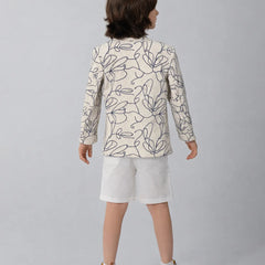 Child wearing a patterned blazer and white shorts on a plain background