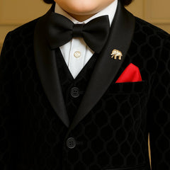 Child wearing a formal black suit with a bow tie and red pocket square.