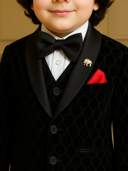 Child wearing a formal black suit with a bow tie and red pocket square.