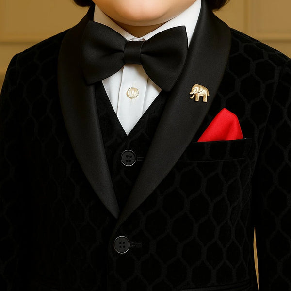 Child wearing a formal black suit with a bow tie and red pocket square.