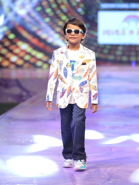 Child model walking on a fashion show runway wearing a printed party wear blazer