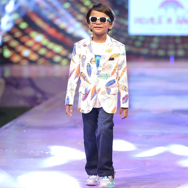 Child model walking on a fashion show runway wearing a printed party wear blazer