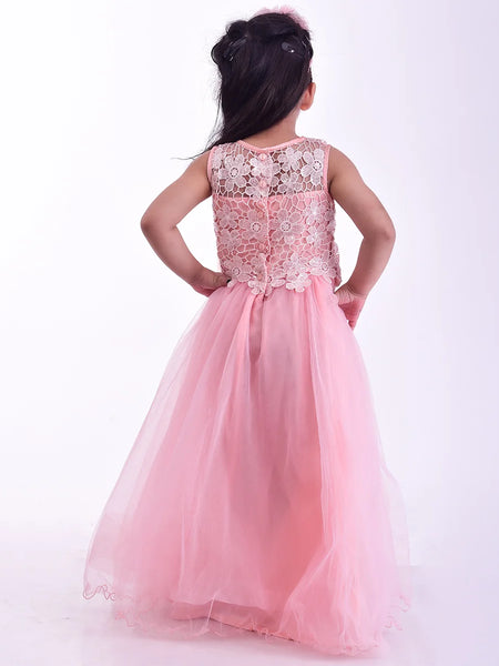 Young girl wearing a pink dress with floral lace details on a white background