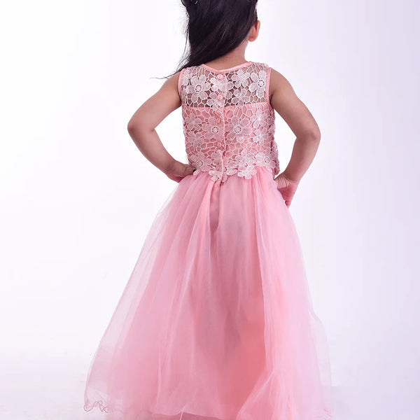 Young girl wearing a pink dress with floral lace details on a white background