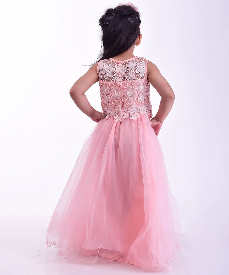 Young girl wearing a pink dress with floral lace details on a white background