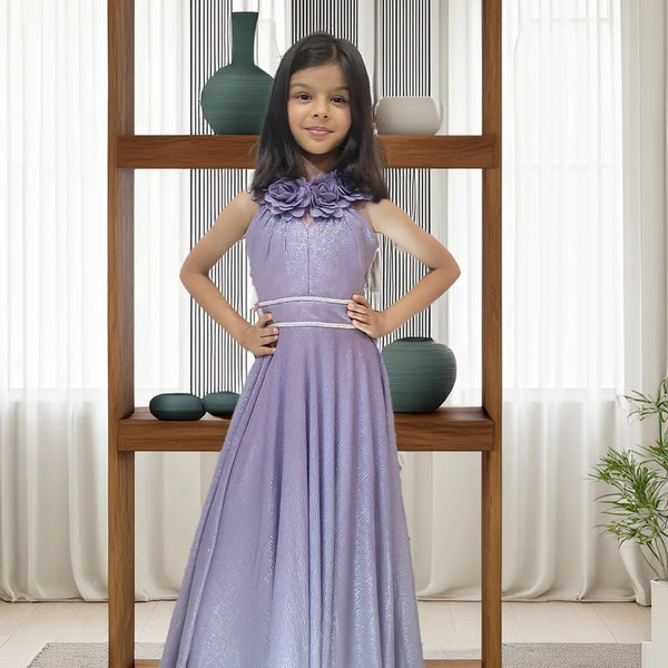 Young girl in a purple dress standing in front of a wooden shelf with decorative vases.