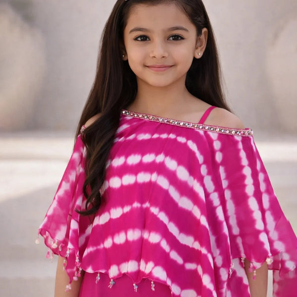 Young girl wearing a pink and white tie-dye top with a blurred background