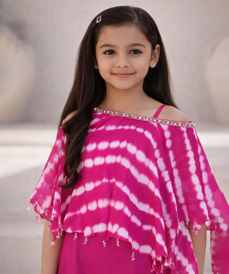 Young girl wearing a pink and white tie-dye top with a blurred background