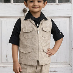 Child wearing a beige vest over a black shirt with a white door background