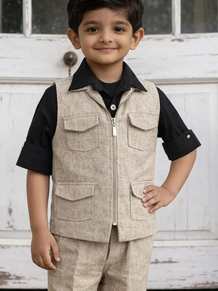 Child wearing a beige vest over a black shirt with a white door background
