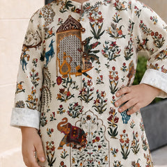 A child wearing a cream-colored kurta with an intricate multicolor hand-block print featuring floral motifs, birds, and an elephant, shown in a lifestyle setting.
