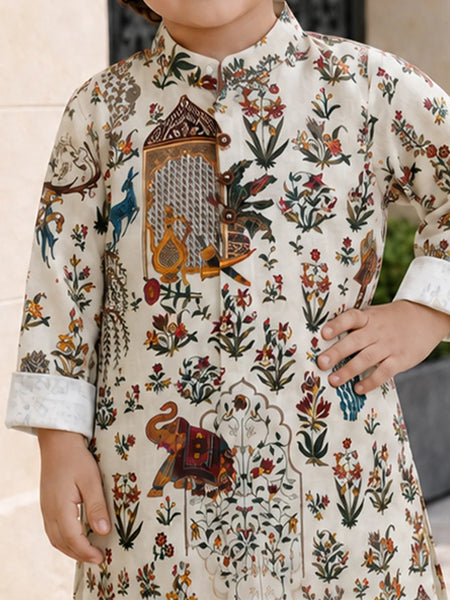 A child wearing a cream-colored kurta with an intricate multicolor hand-block print featuring floral motifs, birds, and an elephant, shown in a lifestyle setting.