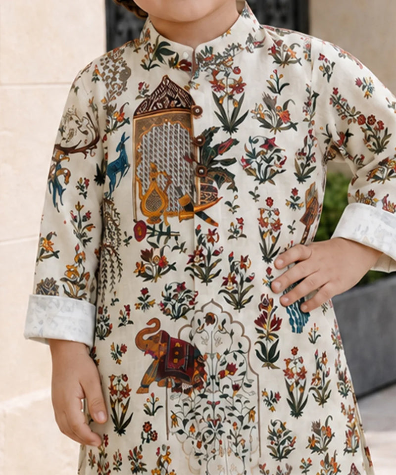 A child wearing a cream-colored kurta with an intricate multicolor hand-block print featuring floral motifs, birds, and an elephant, shown in a lifestyle setting.